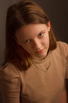 Portrait of a brown-haired model in a light brown t-shirt on a brown backgrou Stock-Fotos
