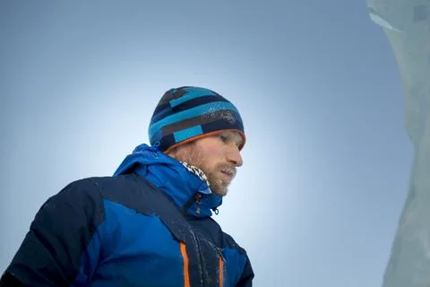 Portrait of a builder in a blue knitted hat and blue winter jacket 스톡 사진