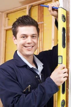 Portrait Of Builder Checking Work With Spirit Level Stock Photos