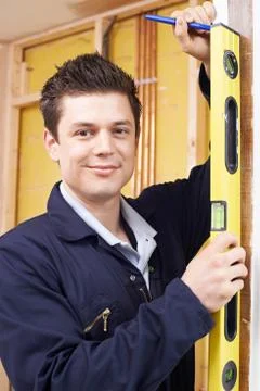 Portrait Of Builder Checking Work With Spirit Level Stock Photos