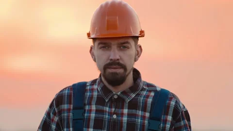 Portrait builder engineer young man with helmet stand look at camera hold tablet Video stock 169773765