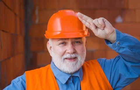 Portrait of builder in hard hat at construction site. Handsome engineer or ar Stock Photos