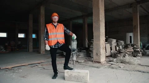 Portrait of a builder man in an orange vest and orange helmet on the background Stock Footage 131370852