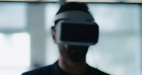 Portrait of a business man using a Virtual Reality headset works and gestures in Stock Footage 199455509