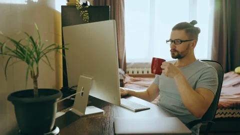 Portrait of a business man working on a computer at home and drinking tea,coffee Video stock 237116798
