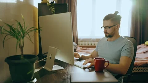 Portrait of a business man working on a computer at home and drinking tea,coffee Stock Footage 256348442