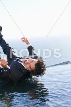 Portrait of a businessman falling into water Stock Photos