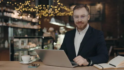 Portrait of businessman looking at camera while working in cafeteria Video stock 170543339