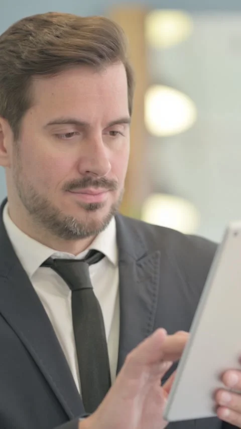Portrait of Businessman using Tablet Computer, vertical video Stock Footage 328554793