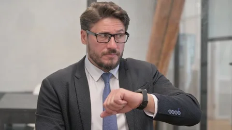 Portrait of Businessman Waiting  and Checking Time on Watch Stockbeeldmateriaal 310175673