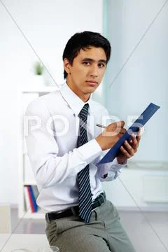 Portrait of a businessman writing plan of work in office Stock Photos