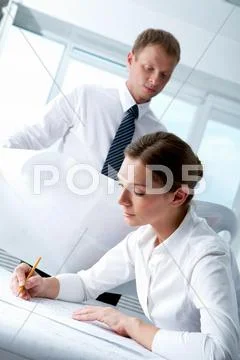 Portrait of busy female drawing construction plan with her boss at background Stock Photos