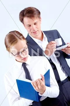 Portrait of busy female making notes with curious man behind Stock Photos