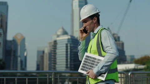 Portrait of busy man engineer talking on smartphone walking along footbridge Stock Footage 311069127