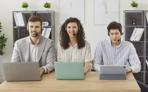 Portrait of call center operator agents in headset working with laptop Stock Photos