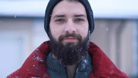 Portrait of calm bearded man looking in camera close-up. Big snowball flies and Stock Footage 112008724