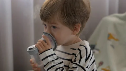 Portrait of a Calm, Cheerful Boy Using Nebulizer. Video stock 293589193