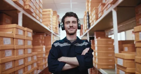 Portrait: The camera moves closer, a man in a blue uniform with headphones poses Stock Footage 244477522