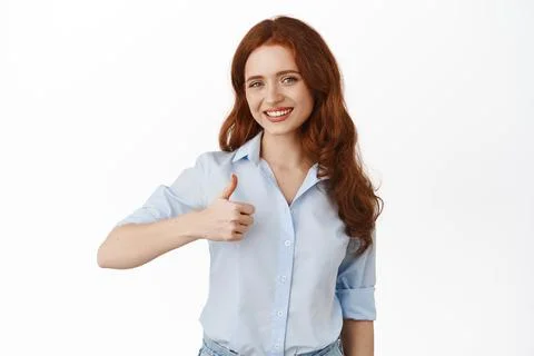 Portrait of candid smiling woman in business clothing, showing thumb up and Stock Photos