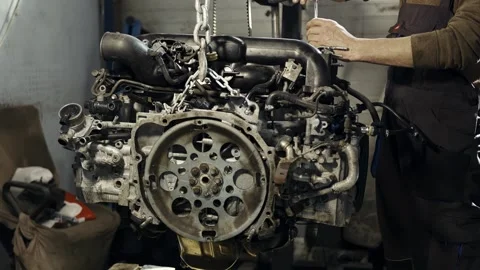 Portrait of a car mechanic with disassembled engine repairs the engine using a Stock Footage 281582505