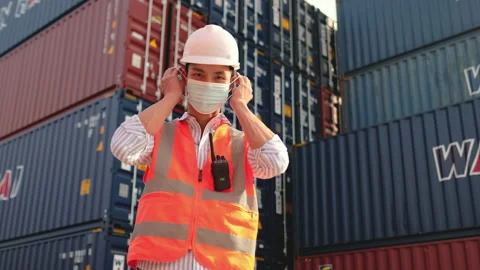 Portrait of cargo container worker or technician wear mask in front of container Stock Footage 146458880