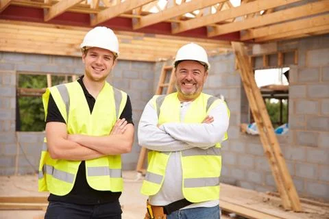 Portrait Of Carpenter With Apprentice Working On Site Stock Photos