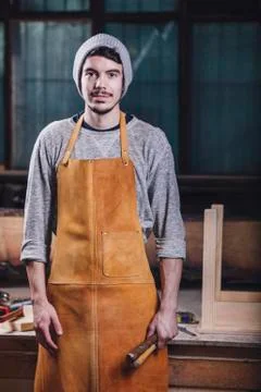 Portrait of carpenter holding hand tools at workshop Stock Photos
