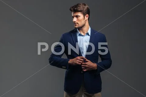 Portrait of a casual handsome man buttoning his jacket Stock Photos