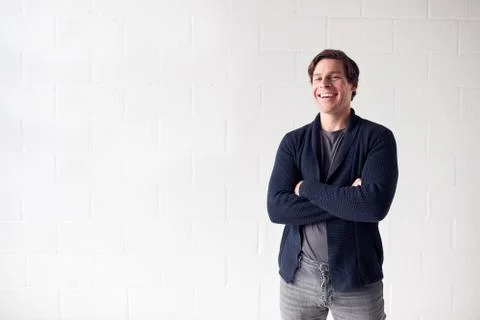 Portrait Of Casually Dressed Smiling Man Standing Against White Studio Wall Stock Photos