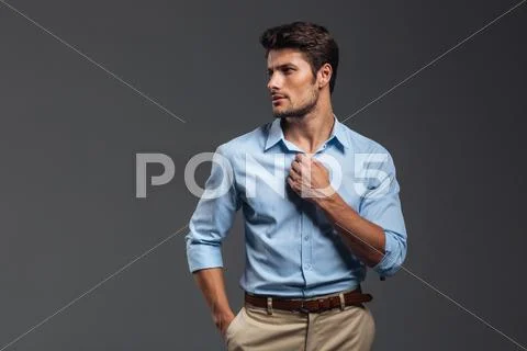 Portrait of a casualman buttoning his shirt isolated Stock Photos