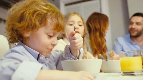 Portrait of caucasian beautiful little boy with blue eyes and blonde hair eating Stock Footage