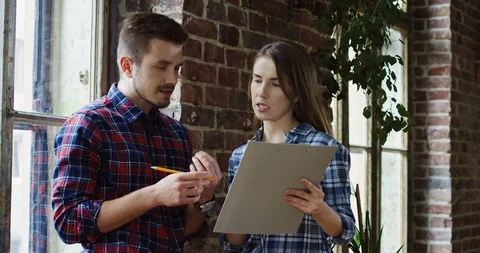 Portrait of the Caucasian good looking young couple of start-uppers with a Stock Footage 101001045