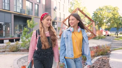 Portrait of Caucasian joyful young beautiful girls with skateboards walking on Stock Footage 200402453