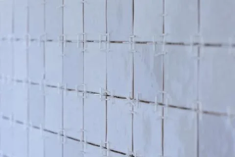 A portrait of a ceramic tile wall under construction. The wall is being til.. Stock Photos