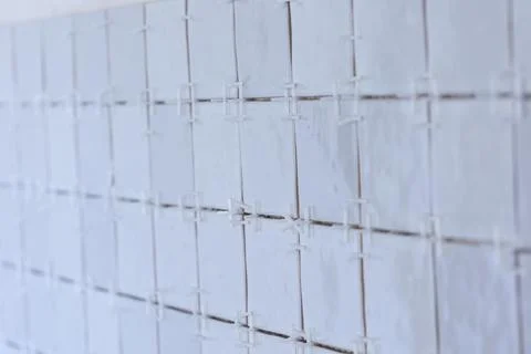 A portrait of a ceramic tile wall under construction. The wall is being til.. Stock Photos