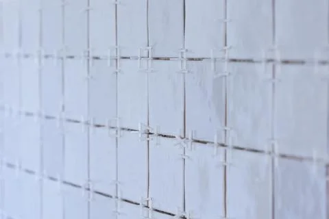 A portrait of a ceramic tile wall under construction. The wall is being til.. Stock Photos