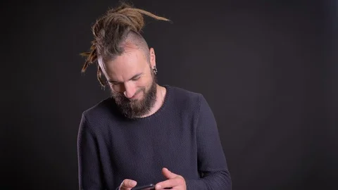 Portrait of charismatic man with dreadlocks and piercing watching into Video stock 100344440