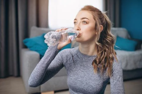 Portrait of charming girl drinking water after workout Stock Photos