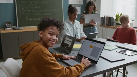 Portrait of Cheerful Black Boy Working with AI Generator at Lesson Stock Footage 318720716