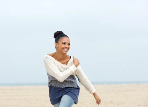 Portrait of a cheerful carefree young woman walking on the beach Stock Photos