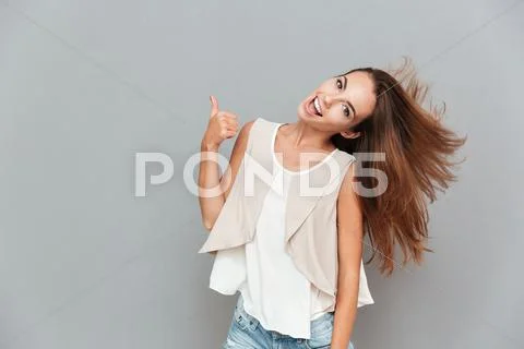 Portrait of a cheerful casual woman showing thumbs up Stock Photos