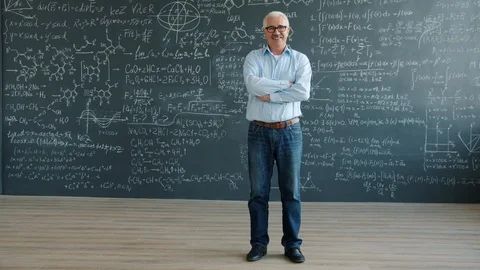 Portrait of cheerful man standing in class with chalkboard wall smiling looking Stock Footage 124869072
