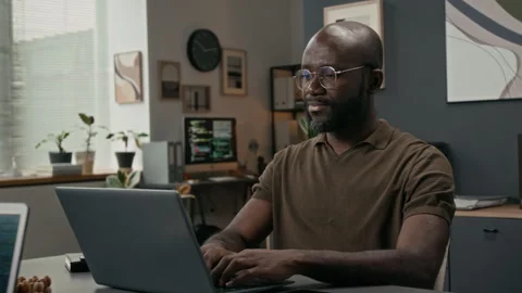 Portrait of Cheerful Programmer Coding on Laptop during Workday in IT Office Stock Footage 329610281