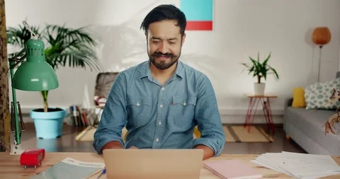 Portrait of cheerful successful Hispanic guy working using laptop touching Stock Footage 120743658
