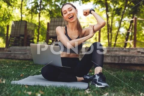 Portrait of a cheerful young fitness girl using laptop Stock Photos