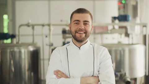 Portrait of a cheese factory worker. The technologist in a white coat looks at Vidéo 175440832