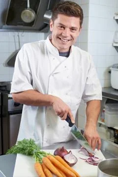 Portrait Of Chef Preparing Vegetables In Restaurant Kitchen Stock Photos