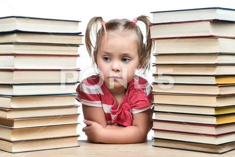 Portrait child between piles of books Stock Photos