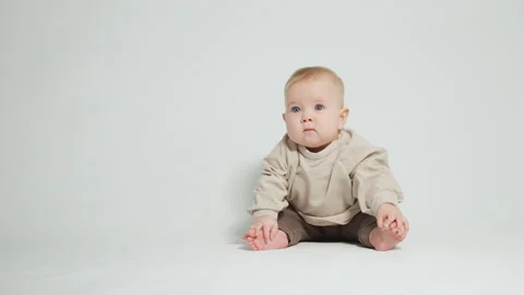 Portrait of a child with chubby cheeks, on a light studio background Stock Footage 242769995