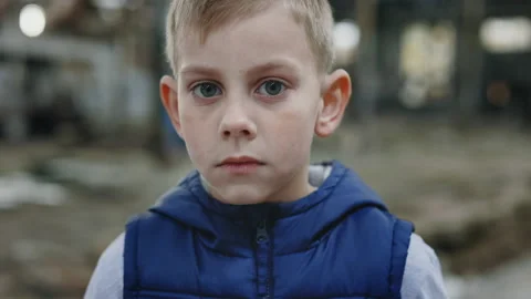 Portrait of the child on the devastation background. A sad little boy who lost Stock Footage 228745728